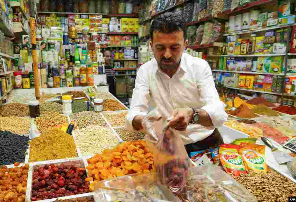 دووکاندارێک لە شاری دهۆک سەرقاڵی فرۆشتنی خواردەمەنییە، لە یەکەم ڕۆژی مانگی ڕەمەزان 2ی مانگی چواری 2022