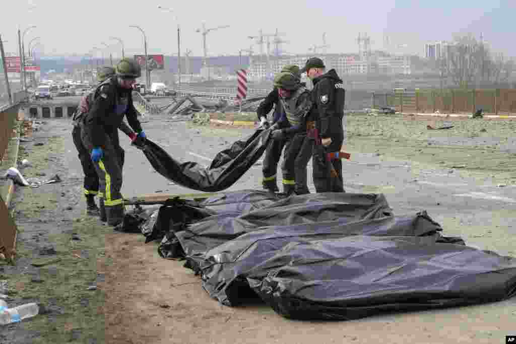 Ukrainian soldiers collect bodies of civilians killed by Russian forces at the destroyed bridge in Irpin, close to Kyiv, Ukraine.