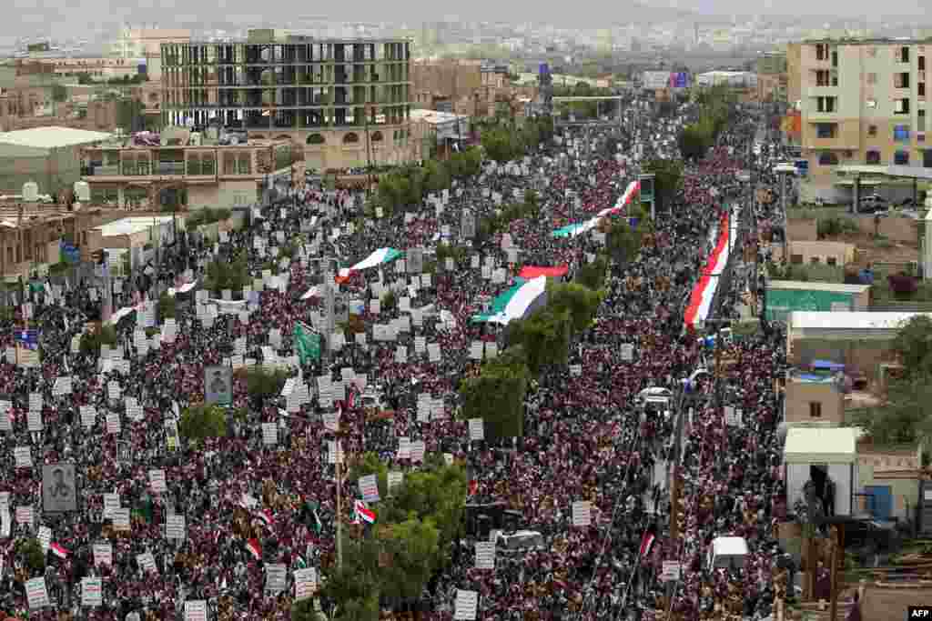 Supporters of Yemen's Shiite Huthi movement lift placards and Palestinian flags during a rally in the capital Sanaa, marking the yearly al-Quds day, which falls on the last Friday of the Muslim holy month of Ramadan