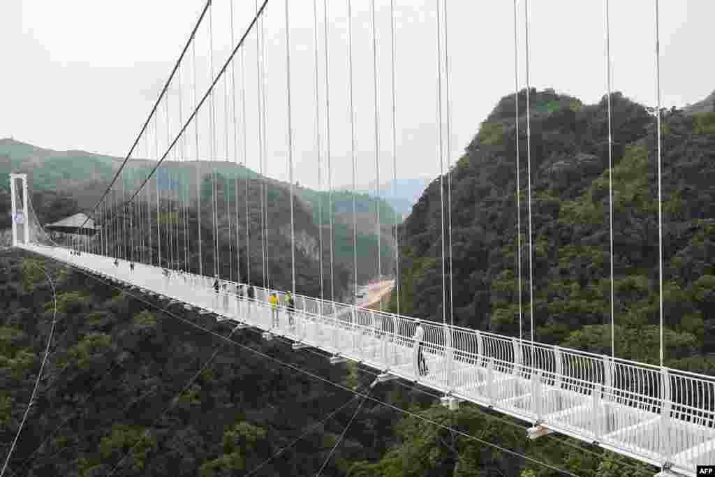 Visitors walk on the Bach Long glass bridge in Moc Chau district in Vietnam's Son La province. Vietnam launched a new attraction for tourists with the opening of a glass-bottomed bridge suspended some 150 metres above a lush, jungle-clad gorge.