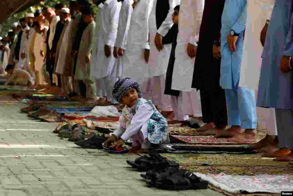 A boy plays as people attend Eid al-Fitr prayers to mark the end of the holy fasting month of Ramadan in Peshawar, Pakistan.