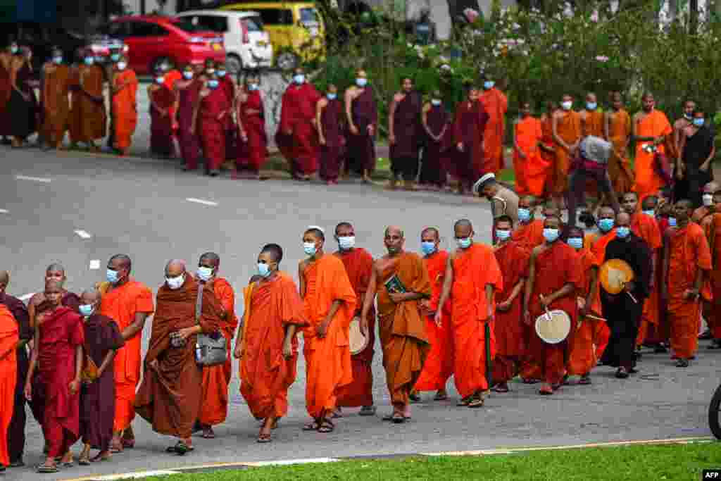 Buddhist monks arrive for a meeting at Colombo's Independence Memorial Hall in Colombo, April 30, 2022, to express their solidarity with countrymen demonstrating against the government over the country's crippling economic crisis.