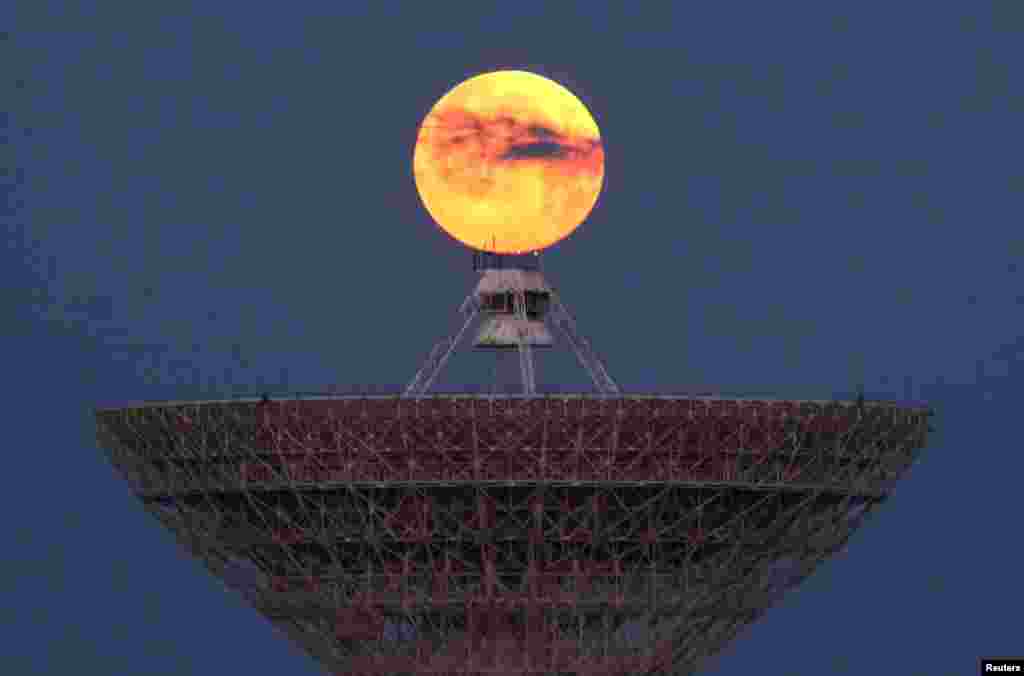 The moon is seen through clouds behind the radio telescope RT-70 in the village of Molochnoye, Crimea.