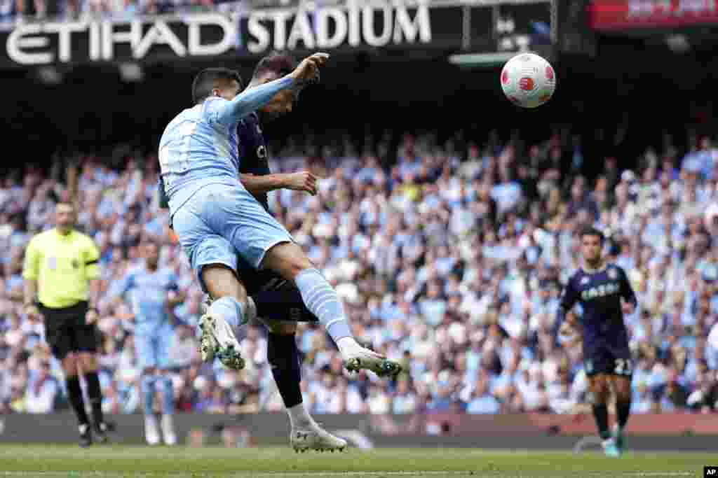 Manchester City's Joao Cancelo, left, fails to stop Aston Villa's Matty Cash from scoring his sides first goal during the English Premier League soccer match between Manchester City and Aston Villa at the Etihad Stadium in Manchester, England.