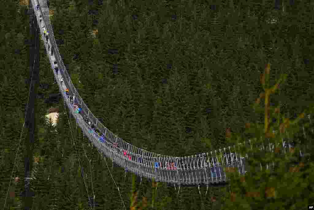 Visitors cross a suspension bridge for pedestrians that is the longest such construction in the world shortly after its official opening at a mountain resort in Dolni Morava, Czech Republic.