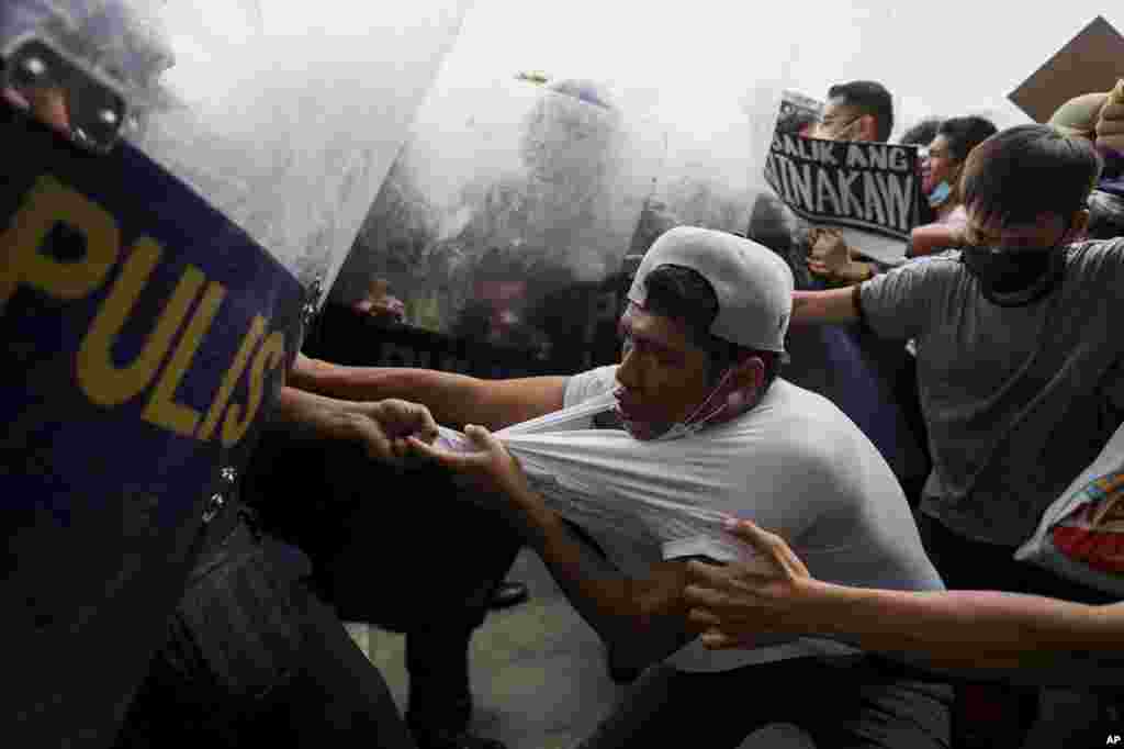 Police disperse activists protesting against the upcoming proclamation of presidential frontrunner Ferdinand "Bongbong" Marcos Jr. and running mate Sara Duterte, daughter of the current president, during a rally at the Commission on Human Rights in Quezon City, Metro Manila, Philippines.