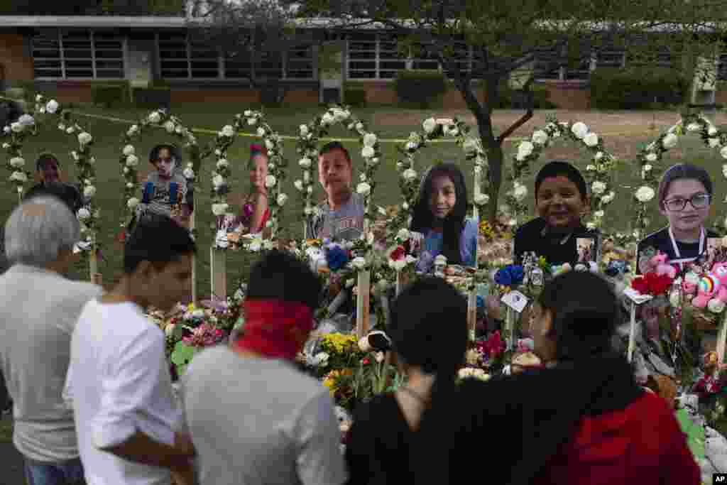 People gather at a memorial at Robb Elementary School in Uvalde, Texas, to pay their respects to the victims killed in last week's school shooting.