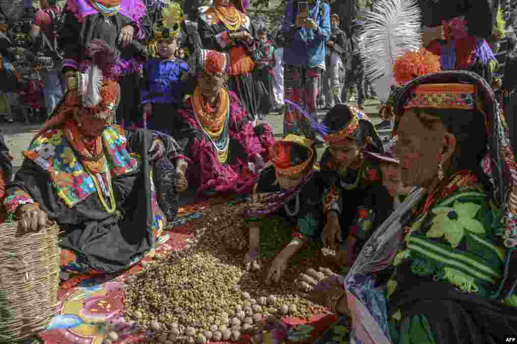 Kalash tribe women wearing traditional dresses arrive to take part in the 'Chilam Joshi' festival celebrating the arrival of spring at Bumburet village, Pakistan.
