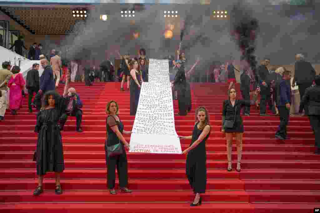 A banner is unveiled with a list of names and that reads at the end "129 feminicides since the last Cannes festival" at the premiere of the film 'Holy Spider' at the 75th international film festival, Cannes, southern France.