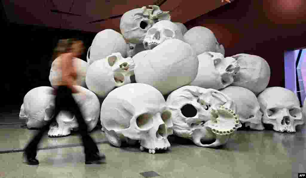 A person looks at Australian artist Ron Mueck's large-scale installation 'Mass' which comprises more than 100 hand-cast skulls that collectively weigh approximately 5000 kilograms at an exhibition at the National Gallery of Victoria in Melbourne.