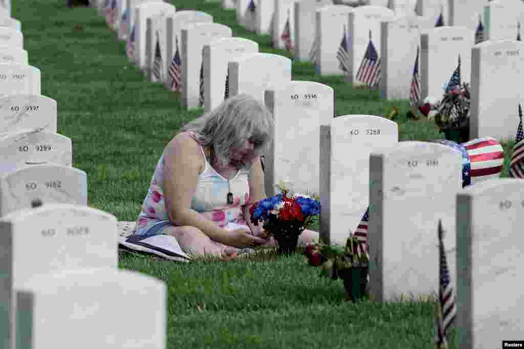 Christine Honeycutt visits the grave site of her son LCPL USMC Terry Edward “TJ” Honeycutt in section 60 at Arlington National Cemetery in Arlington, Virginia, May 29, 2022.