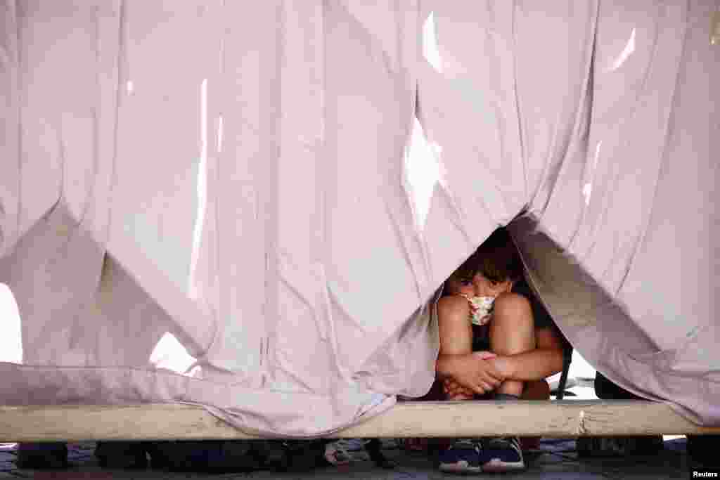 A child sits on the ground during the weekly general audience held by Pope Francis at the Vatican.