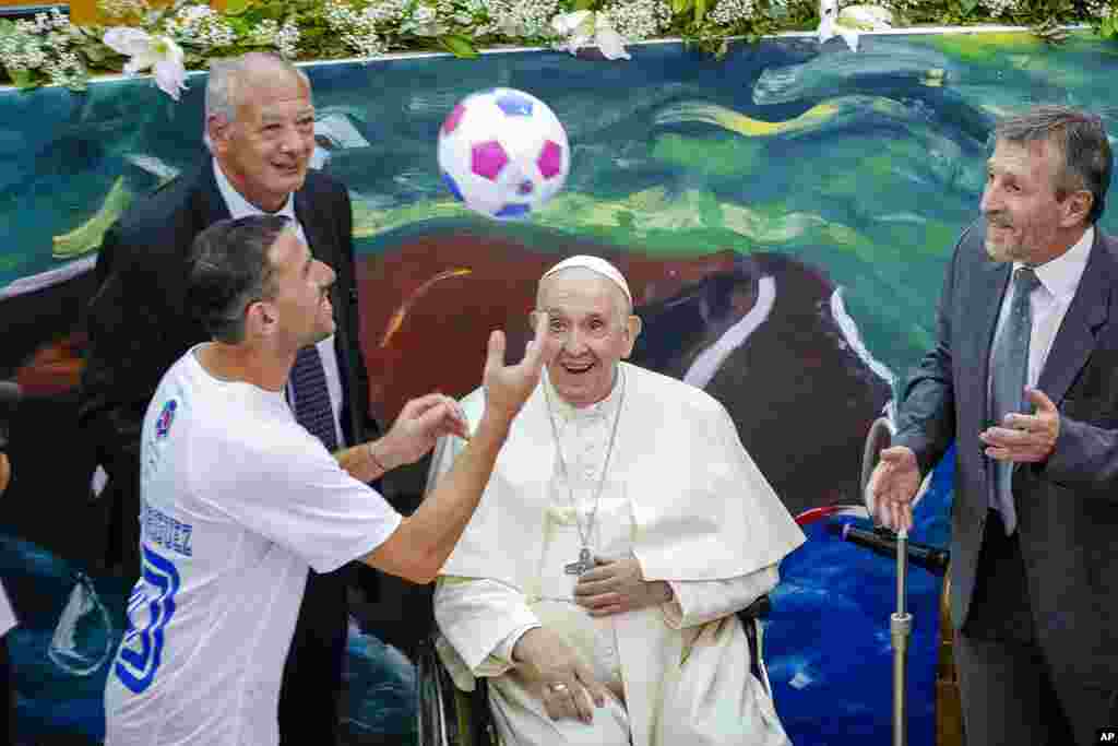 Paus Fransiskus melihat gelandang Argentina Maxi Rodriguez memainkan bola pada peluncuran sekolah "Scholas Occurrentes", yayasan pendidikan internasional di Universitas Kepausan Urbaniana di Roma. (Foto: AP)