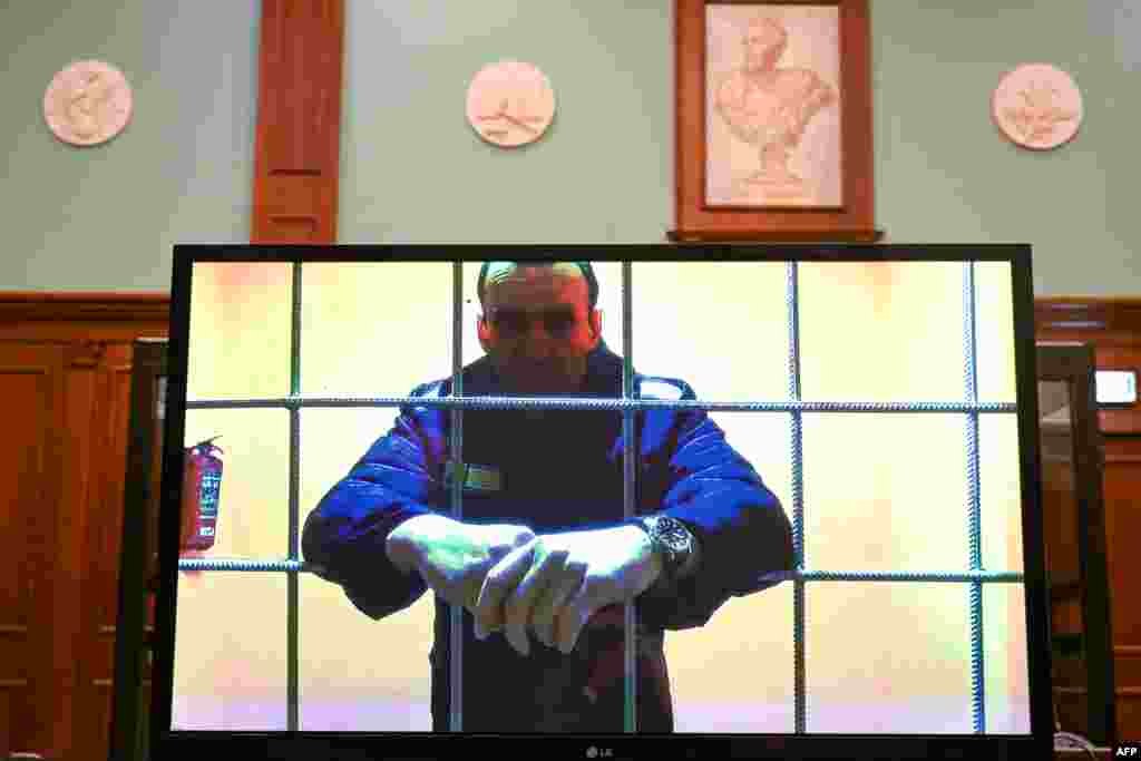 Opposition leader Alexey Navalny appears on a screen set up at a courtroom of the Moscow City Court via a video link from his prison colony during a hearing of an appeal against his nine-year prison sentence he was handed in March after being found guilty of embezzlement and contempt of court, in Moscow.