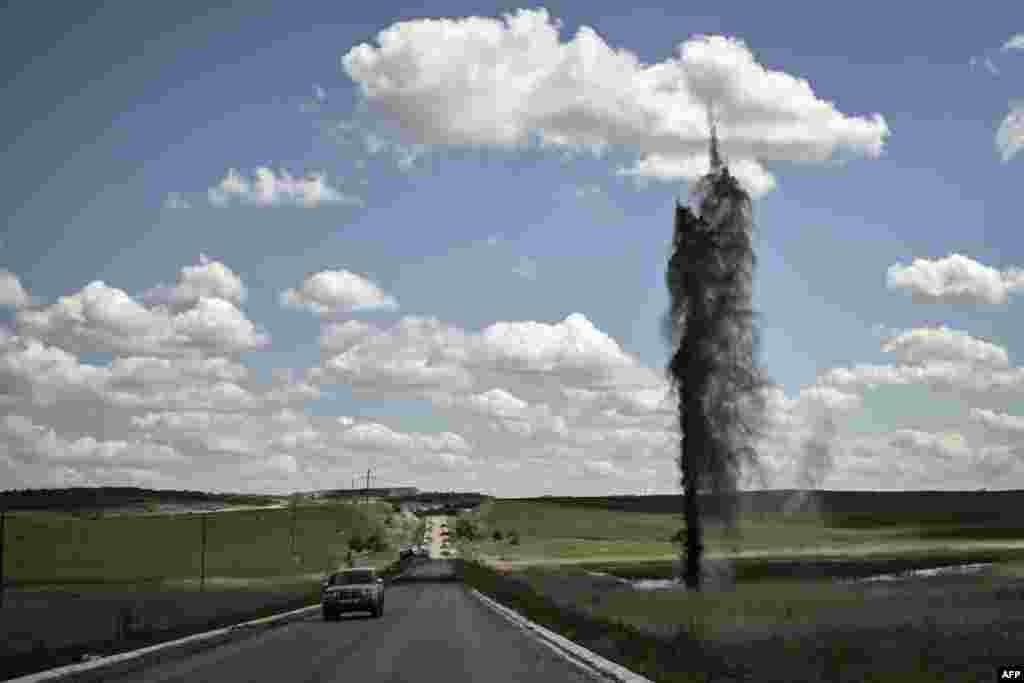 A mortar explodes next to the road leading to the city of Lysychansk in the eastern Ukranian region of Donbas, amid Russian invasion of Ukraine.