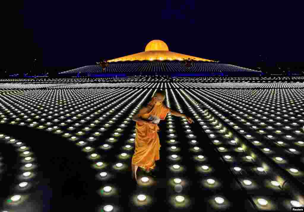 A Buddhist monk places the LED lights as people observe Vesak Day, an annual celebration of Buddha's birth, enlightenment and death, at Dhammakaya Temple, Pathum Thani, near Bangkok, Thailand.