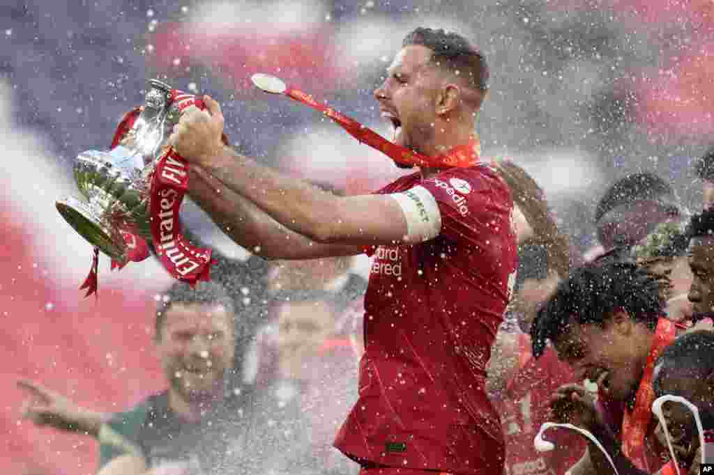 Liverpool's Jordan Henderson celebrates with the trophy at the end of the English FA Cup final soccer match between Chelsea and Liverpool, at Wembley stadium in London, May 14, 2022.