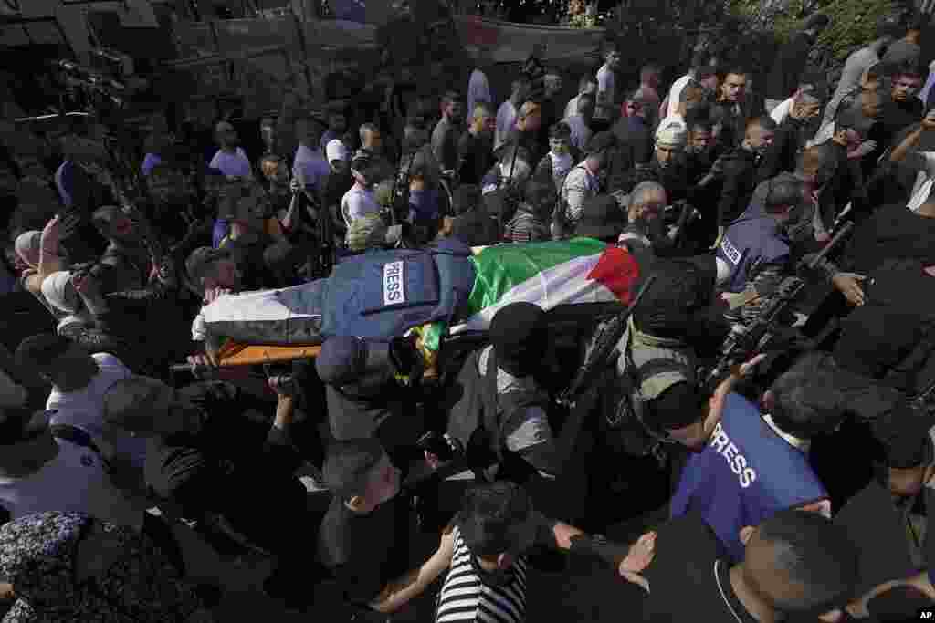 Palestinian militants carry the body of Shireen Abu Akleh, a journalist for Al Jazeera network, in the West Bank town of Jenin. The well-known Palestinian reporter was shot and killed while covering an Israeli raid, the Palestinian health ministry said.