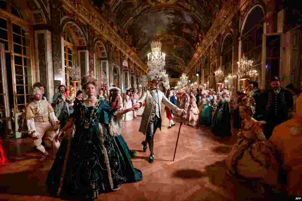 Guests wearing baroque style costumes walk in the Hall of Mirrors at the Chateau de Versailles Palace as part of the sixth edition's of the Fetes Galantes fancy dress evening which theme is the Royal Wedding of Marie Antoinette and Louis XVI, in Versailles, France, May 23, 2022.
