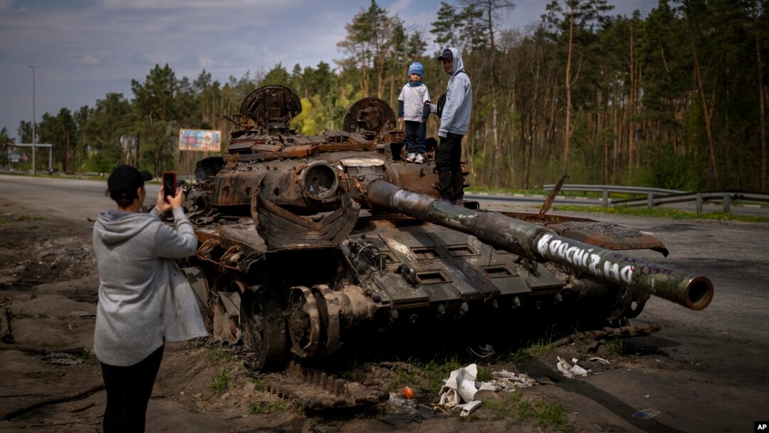 Watu wanaopiga picha wakiwa juu ya mizinga ya Russia iliyoharibiwa Kyiv, Ukraine. May 8, 2022