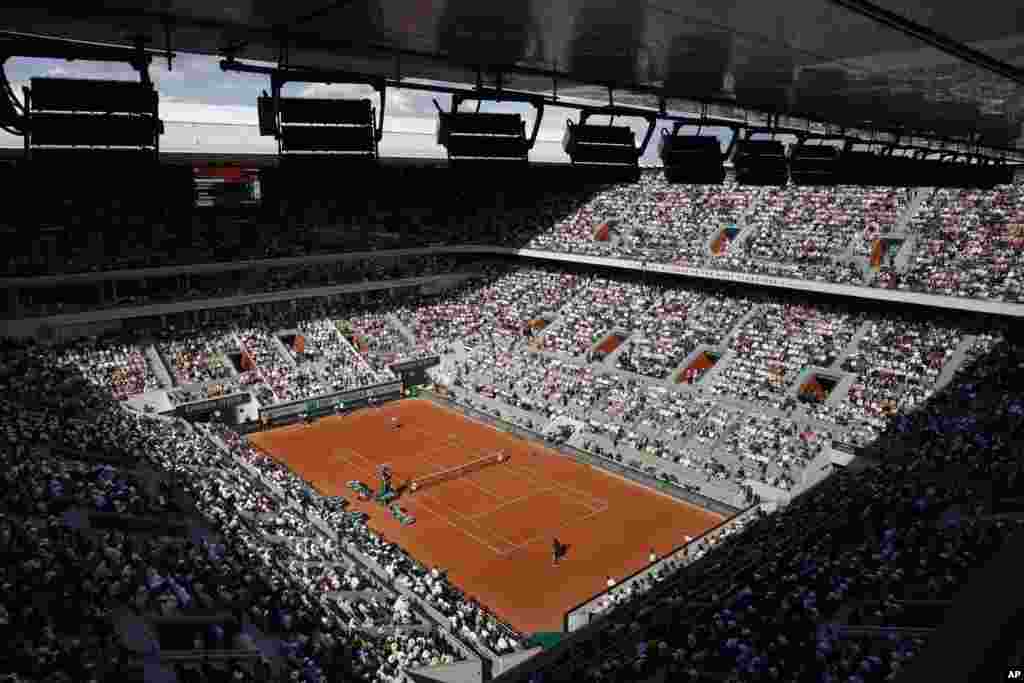 The public watch Spain's Carlos Alcaraz playing Germany's Alexander Zverev, front, during their quarterfinal match of the French Open tennis tournament at the Roland Garros stadium in Paris.