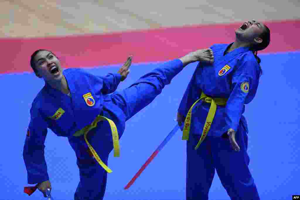 Cambodia's Pov Sokha and Soeur Chanleakhena compete in the female pair sword form category of the vovinam event during the 31st Southeast Asian Games (SEA Games) in Hanoi.