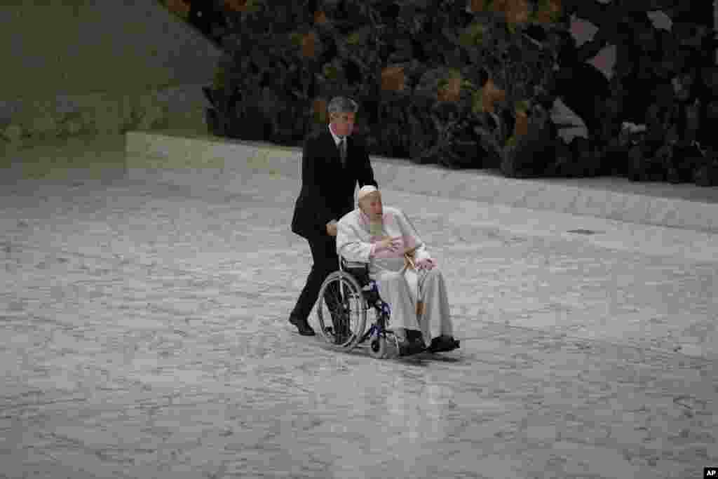 Pope Francis arrives in a wheelchair to attend an audience with nuns and religious superiors in the Paul VI Hall at The Vatican. Francis, 85, has been suffering from strained ligaments in his right knee for several months.