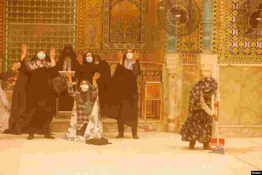 Iranian women pray during a sandstorm at the Imam Ali Shrine in Najaf, Iraq.