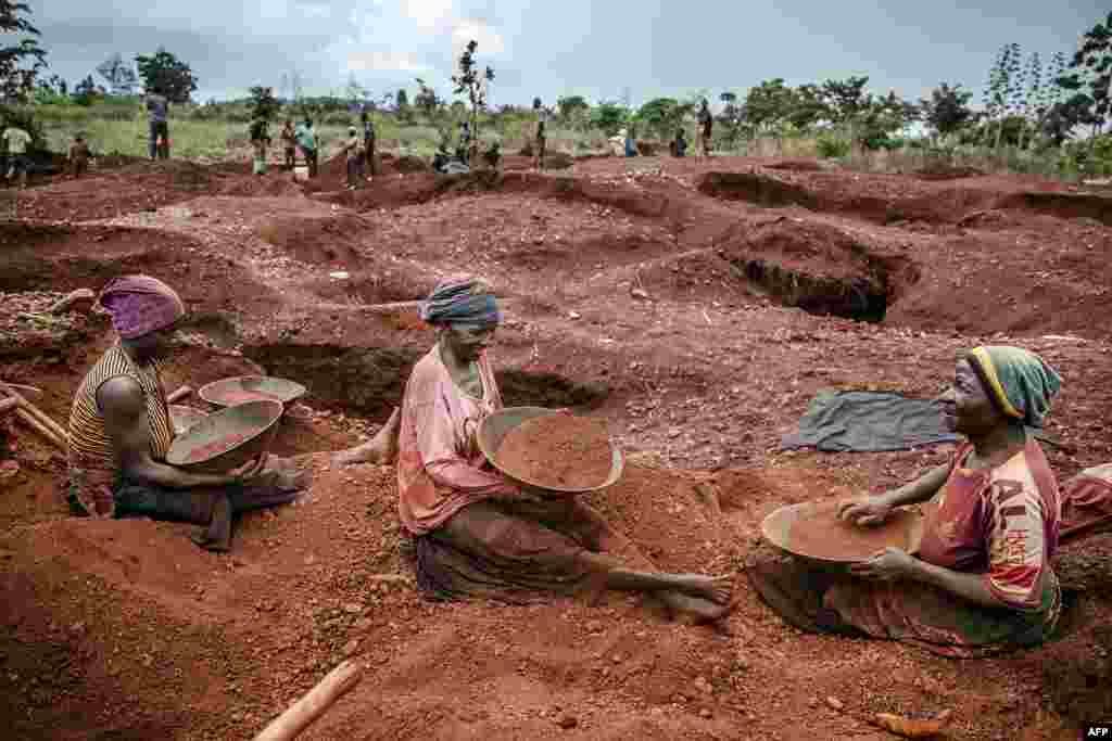 Tanzanian miners Mwagyma Ramadhan, Regina Daud and Maria Ng'ombe look for gold at an open-pit gold mine in Nyarugusu, Geita Region.
