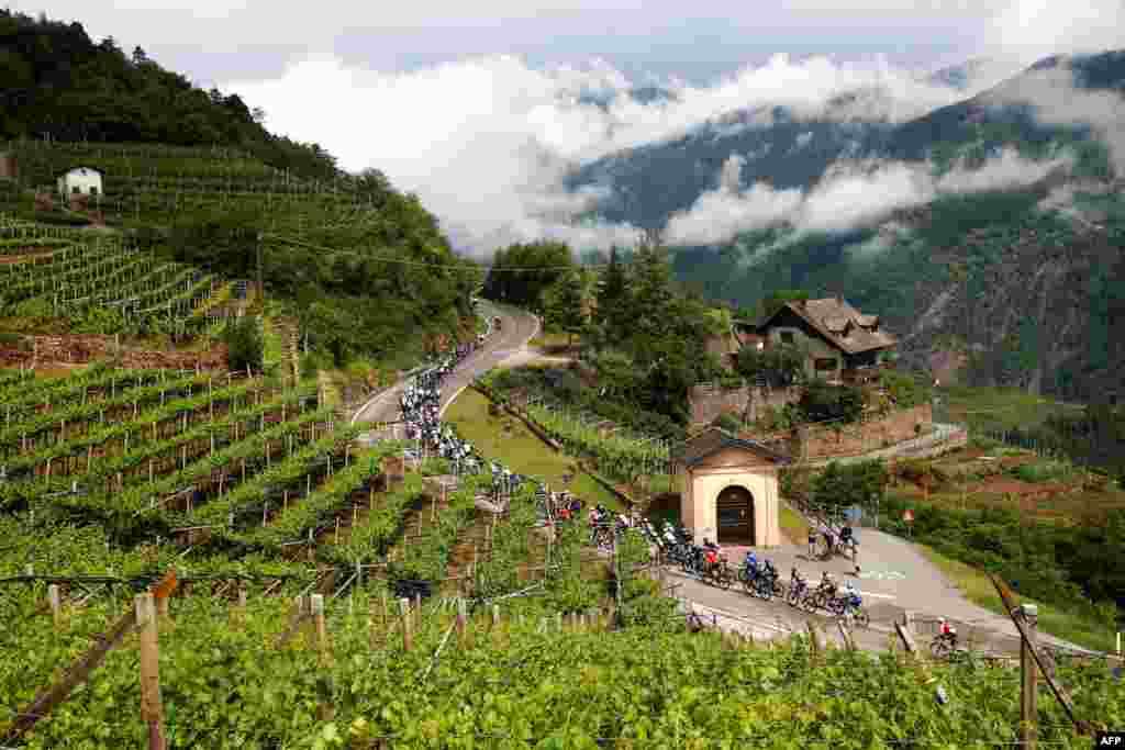 The pack rides near Lisignago village during the 17th stage of the Giro d'Italia 2022 cycling race, 168 kilometers from Ponte di Legno to Lavarone, Italy.