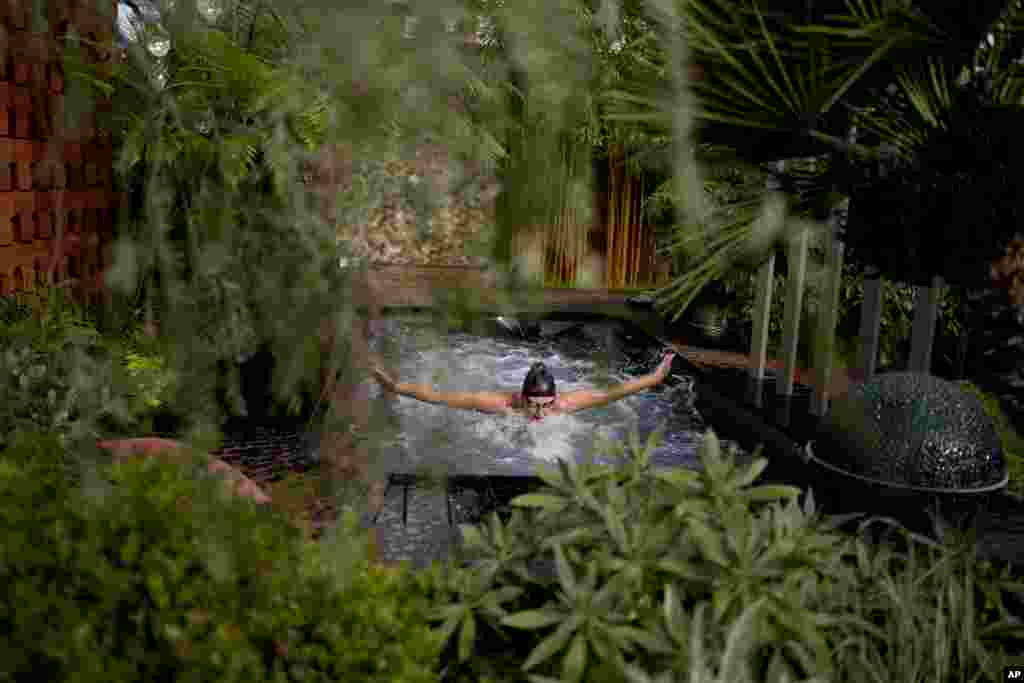 Gold medal winning British Paralympic swimmer Jessica-Jane Applegate poses for photographers by swimming butterfly in a swim spa which forms part of the "Out Of The Shadows" show garden during the Chelsea Flower Show in London.