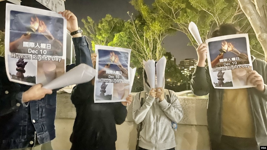 4名中國內地留學生12月10日國際人權日，在香港中文大學校園內舉起白紙火炬及標語，呼籲各界關注中國內地”白紙示威”被捕人士，敦促當局盡快放人。(美國之音湯惠芸)