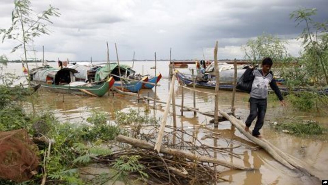A Cambodian man walks on a bridge from his fishing wooden boat at Mekong river bank near Phnom Penh, Cambodia, July 27, 2011