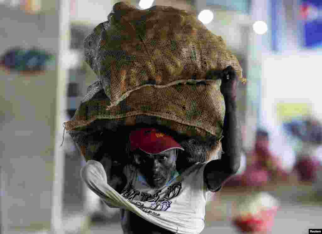 A man carries sacks of carrots at a wholesale market amid the country's economic crisis in Colombo, Sri Lanka.