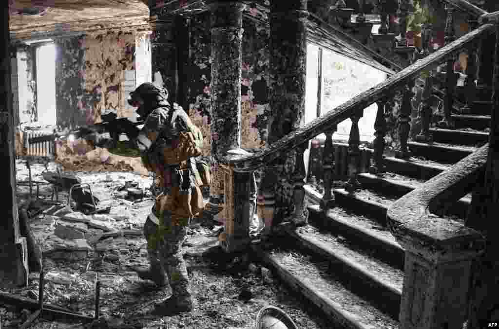 A Russian soldier patrols the Mariupol drama theater that was bombed last month as Russian troops intensify a campaign to take the strategic port city of Mariupol. This picture was taken during a trip organized by the Russian military.