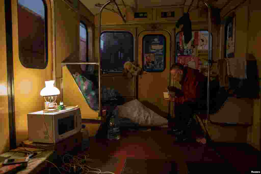 A young man eats inside a subway car, as residents find shelter from shelling in a metro station in Kharkiv amid Russia's invasion of Ukraine, April 11, 2022.
