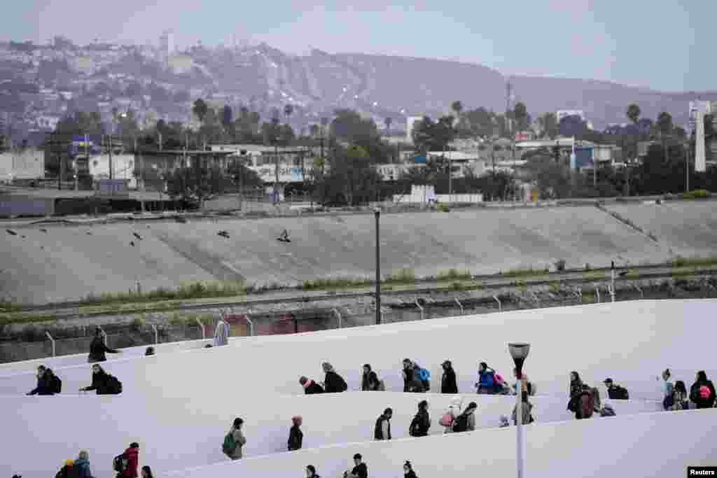 Ukrainians seeking asylum in the United States cross the El Chaparral port of entry in Tijuana, Mexico, April 11, 2022.