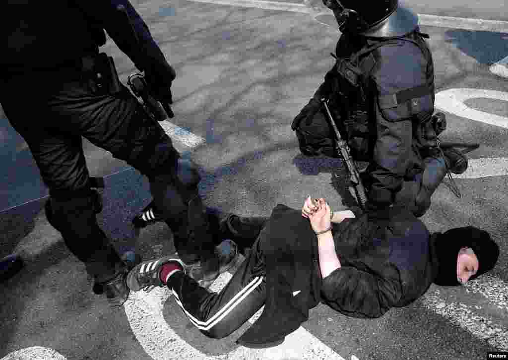 A protester is detained by riot police officers during a demonstration against a gathering held by Spain's far-right party VOX in Barcelona, Spain, March 30, 2019.