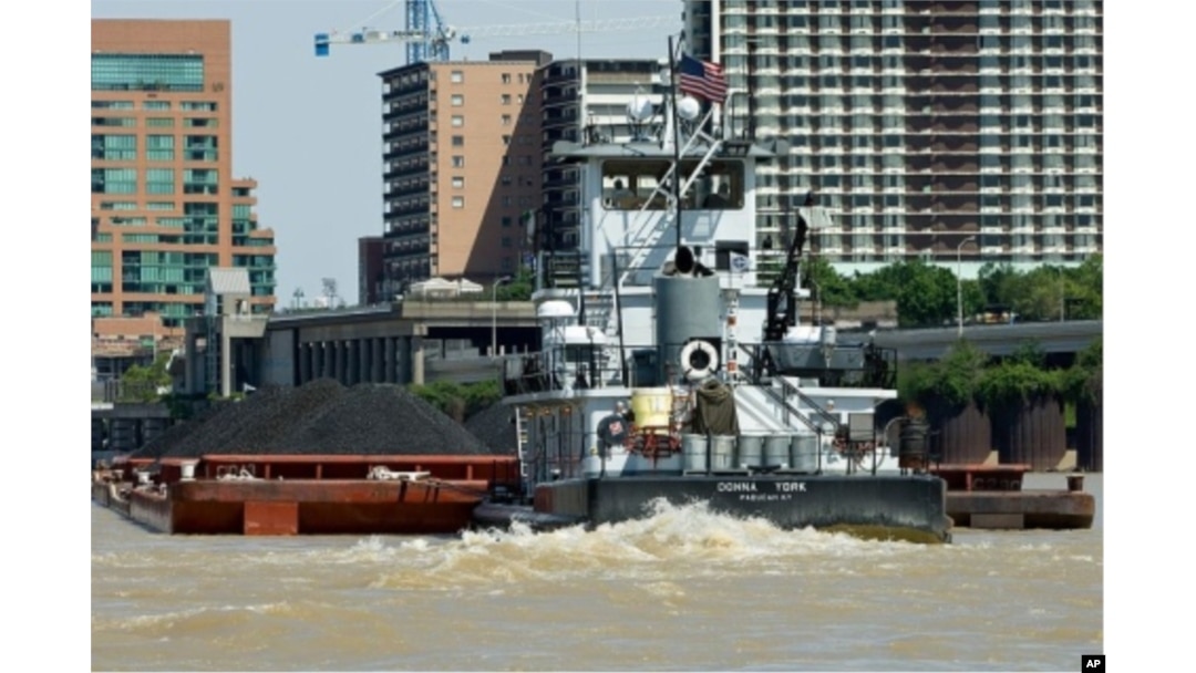 FILE - A tugboat pushes a barge loaded with coal up the Ohio River, past downtown Louisville, Kentucky.