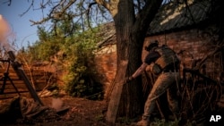 En esta fotografía proporcionada por el servicio de prensa de la 24ta Brigada de Infantería Mecanizada, un soldado ucraniano dispara morteros hacia posiciones rusas en la línea de combate desde un punto no revelado en la región de Donetsk, Ucrania, el 4 de junio de 2024.