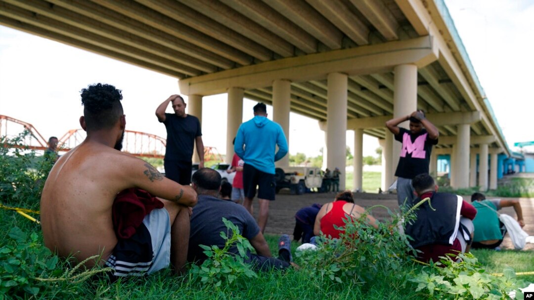 Migrantes esperando a ser procesados por la Patrulla Fronteriza tras cruzar de forma ilegal el Río Bravo desde México y hasta Estados Unidos, en Eagle Pass, Texas, el 26 de agosto de 2022.