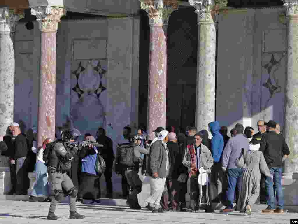Palestinians are kept at bay by Israeli police during clashes at Jerusalem's Al-Aqsa mosque compound.