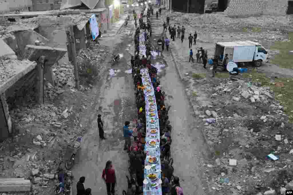 Syrians break their fast during an iftar gathering organised in Tadef, near the border city of al-Bab, which is controlled by Turkish-backed rebels in Syria's eastern countryside of Aleppo province, April 18, 2022.