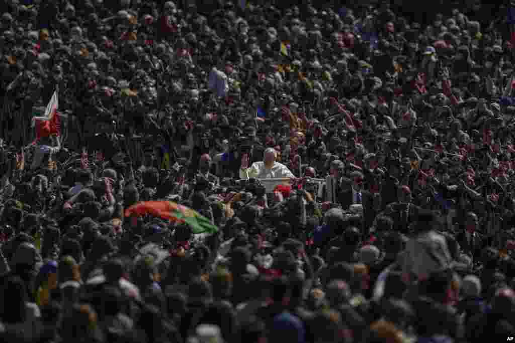Pope Francis on his popemobile drives through the crowd of faithful at the end of the Catholic Easter Sunday mass he led in St. Peter's Square at the Vatican.