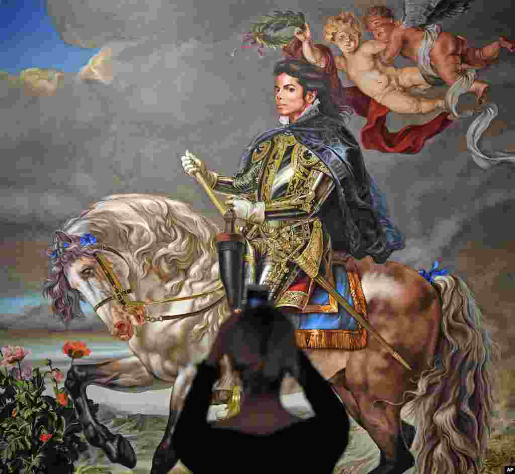 A visitor takes a smartphone picture of the painting 'Equestrian portrait of King Philipp II (Michael Jackson)' from US artist Kehinde Wiley at a preview of the exhibition 'Michael Jackson: On The Wall' at the Bundeskunsthalle museum in Bonn, Germany.