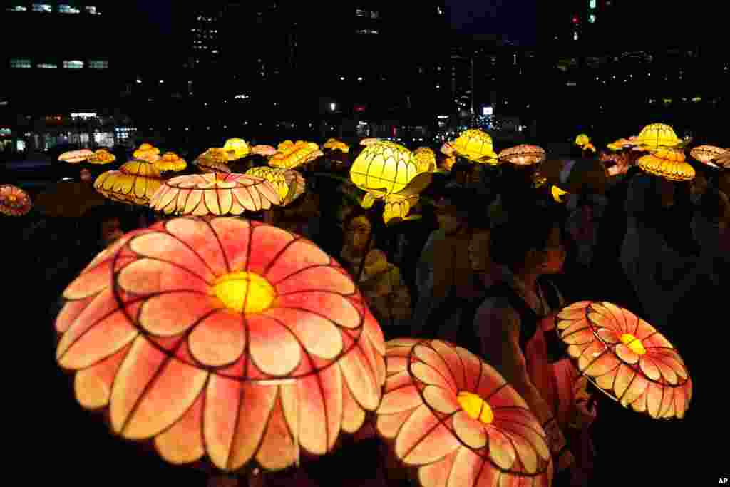 South Korean Buddhists wearing face masks carry colorful lotus lanterns during a lighting ceremony in Seoul to celebrate the upcoming birthday of Buddha on May 8.
