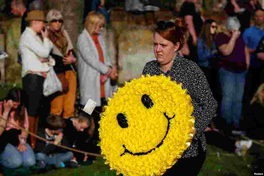A floral wreath in the shape of a smiley face is carried during the funeral of British singer Keith Flint of techno group 'The Prodigy,' in Braintree, Essex, Britain.