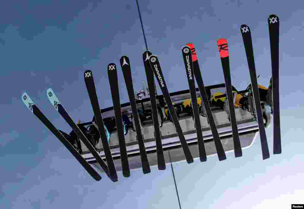 Skiers sit in a chairlift during the winter season opening day at Germany's highest mountain, the Zugspitze, in Grainau, near Garmisch-Partenkirchen, Germany.