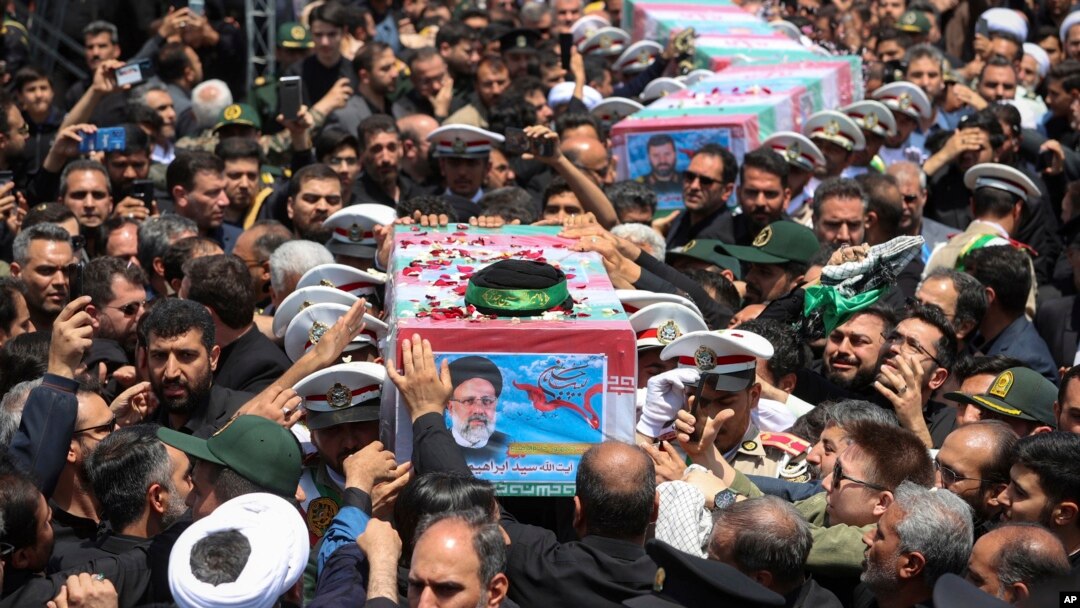 Imagen difundida por la Presidencia Iraní muestra los ataúdes, envueltos en banderas, del presidente Ebrahim Raisi y quienes lo acompañaban en el choque del helicóptero en que viajaban el domingo, durante su funeral en la ciudad de Mashhad, Irán, el 23 de mayo de 2024.