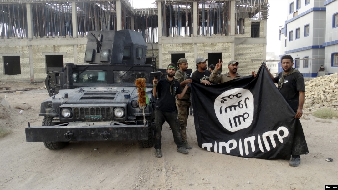 지난해 7월 이라크 안바르 주에서 정부군이 수니파 무장단체 ISIL이 점령했던 지역을 탈환한 후 ISIL 깃발을 거꾸로 들고 있다. (자료사진)